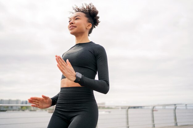 Entrenador de fitness es un instructor de ejecución Ejercicios de fitness de mujer de entrenamiento para cardio con reloj inteligente