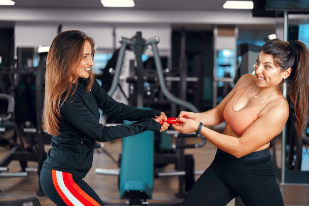 Entrenador de fitness mujer y su cliente en un gimnasio