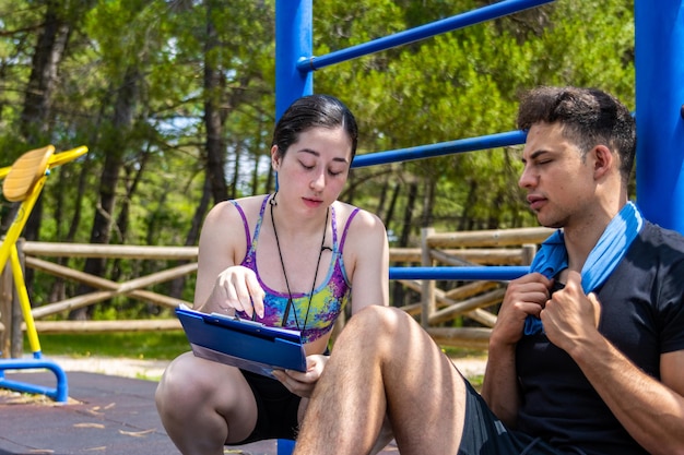 Entrenador de fitness revisando el plan de entrenamiento con el atleta