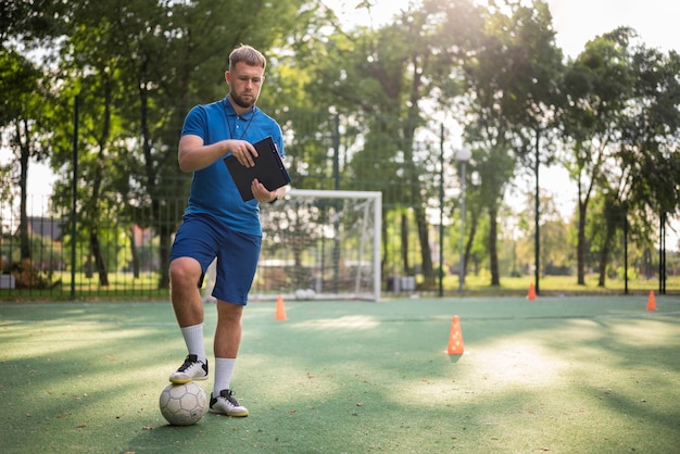 Foto entrenador de fútbol enseñando a sus alumnos