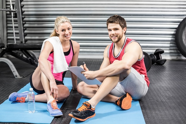 Entrenador hablando con su cliente en el gimnasio de crossfit.