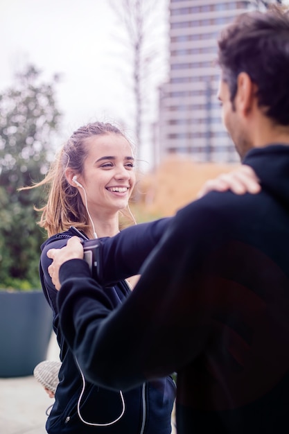 Entrenador masculino ayudando a joven haciendo ejercicio al aire libre