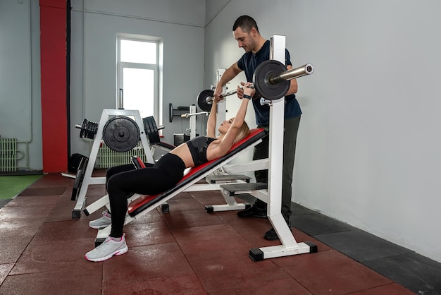 Entrenador masculino de fitness con su cliente trabajando haciendo ejercicio en el gimnasio Entrenamiento de concepto de energía