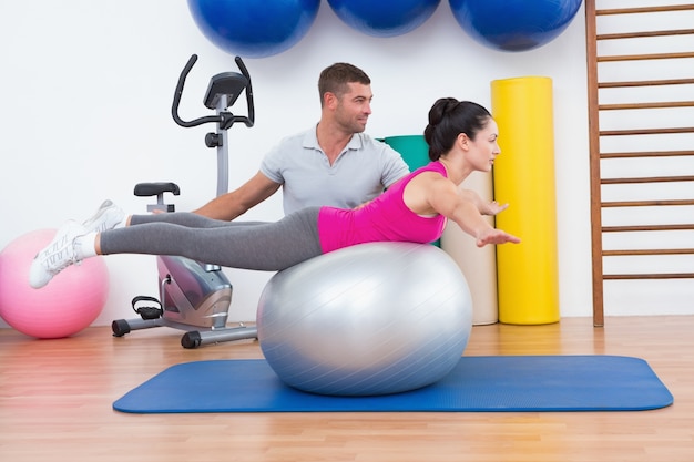 Entrenador con mujer en ejercicio de pelota