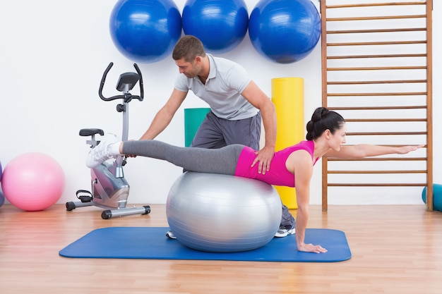 Entrenador con mujer en ejercicio de pelota