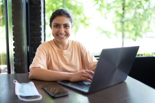 Entrenador de negocios indio mujer trabajando en su computadora portátil al aire libre.
