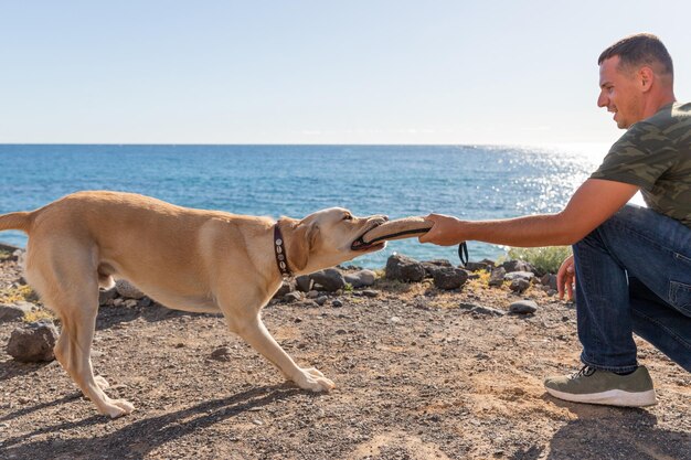 Un entrenador de perros durante un entrenamiento con un perro que muerde el juguete remolcador