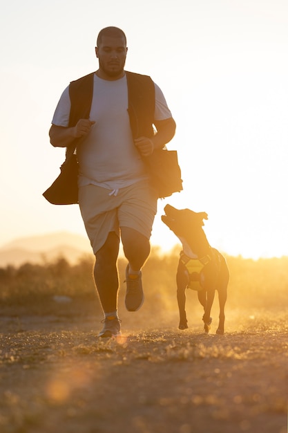 Foto entrenador de perros saltando con perro