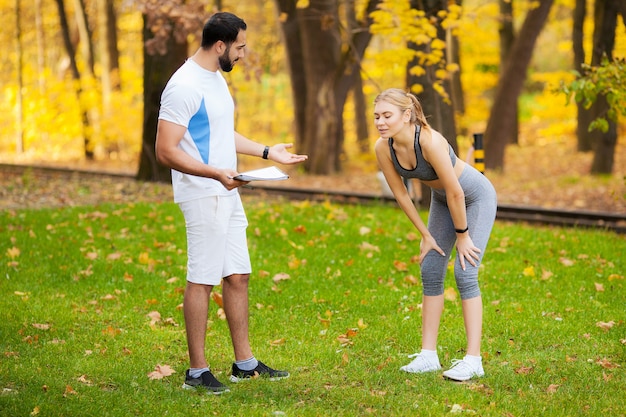 Entrenador personal masculino que muestra resultados a su clienta