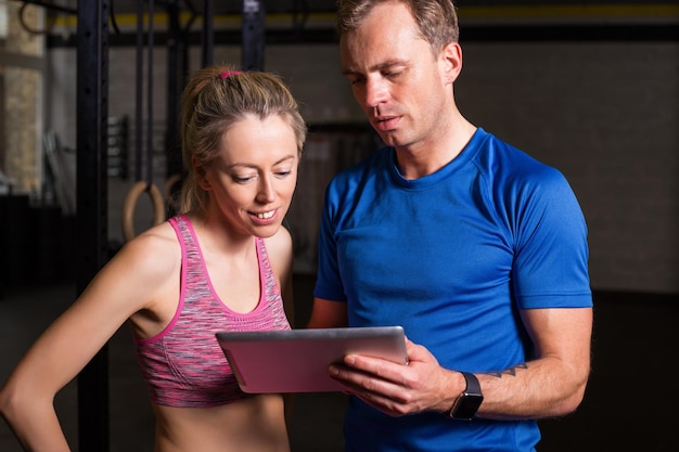 Entrenador personal que muestra el plan de entrenamiento de la mujer