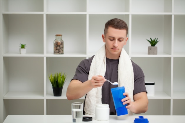 Entrenador prepara un batido de proteínas en el agitador después del entrenamiento