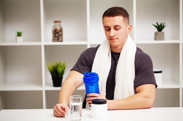 Entrenador prepara un batido de proteínas en la coctelera después del entrenamiento