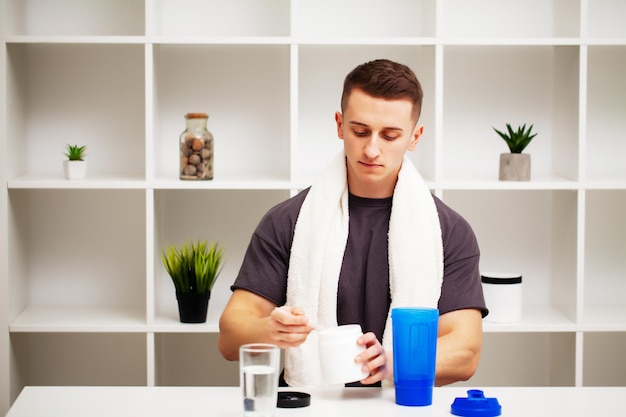 Entrenador prepara un batido de proteínas en la coctelera después del entrenamiento