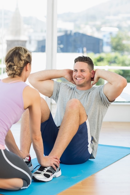 El entrenador que ayuda al hombre en forma se sienta