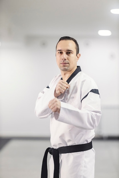Foto un entrenador de taekwondo en posición de ataque en una escuela de artes marciales