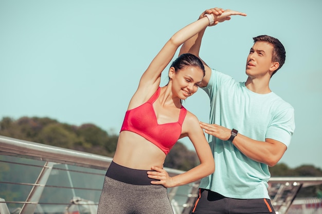 Entrenadora y atleta femenina haciendo ejercicio en el puente de la ciudad