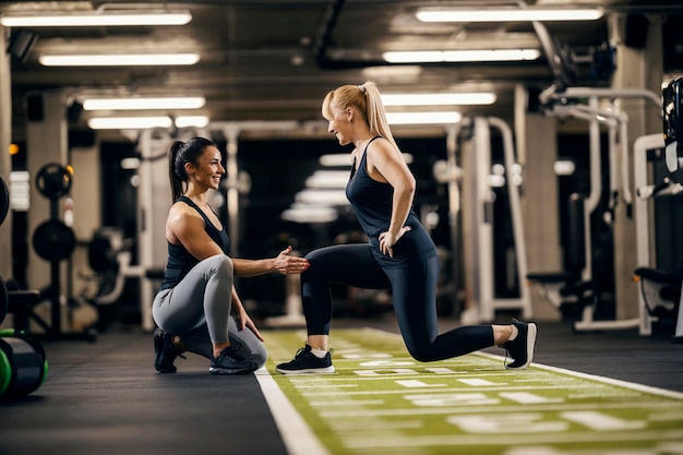 Una entrenadora está entrenando a una deportista en un gimnasio.