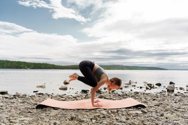 Entrenadora femenina entrenando en ejercicios de yoga de la naturaleza en la colchoneta ropa deportiva Salud Mental y Meditación