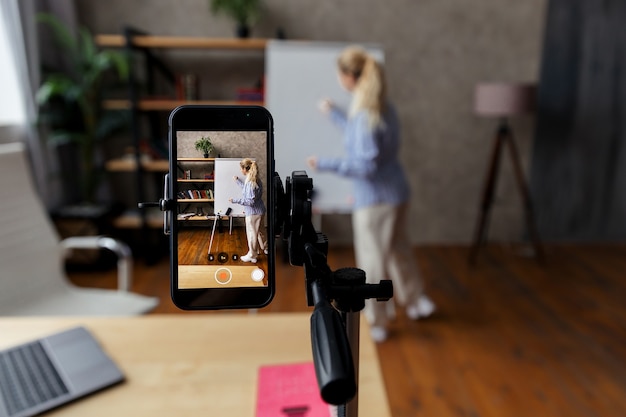 Foto entrenadora de negocios, tutora que realiza seminarios web, capacitación en línea. el mentor en línea realiza una lección en video. centrarse en el teléfono. foto de alta calidad