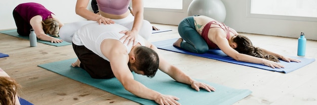 Entrenadora y sus alumnos haciendo pose de Balasana