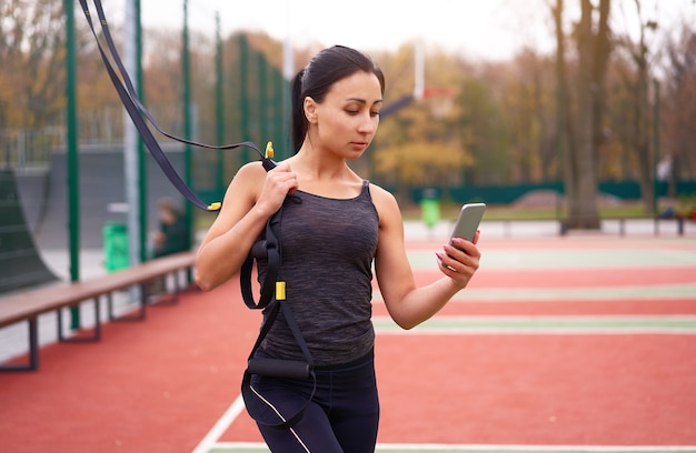 Entrenamiento de atleta chica usando trx en sportground