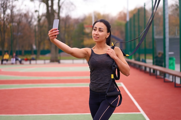 Entrenamiento de atleta chica usando trx en sportground