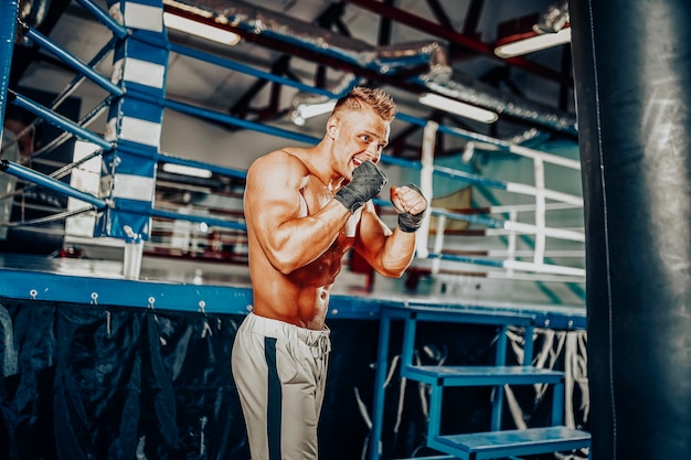 Entrenamiento de boxeador en un saco de boxeo en el gimnasio