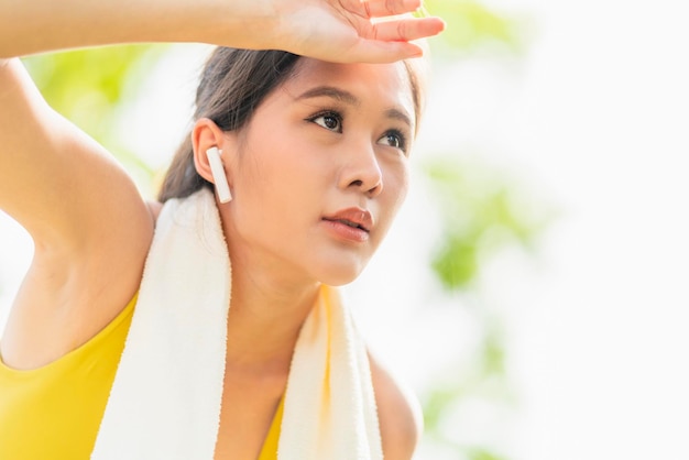 Entrenamiento de corredora activa asiática de pie doblada y recuperando el aliento después de una sesión de carrera en el jardín del parque Mujer deportiva tomando un descanso después de una carrera en el estilo de vida de ejercicio matutino