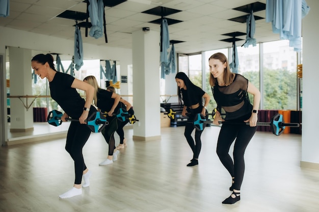 Entrenamiento deportivo y concepto de estilo de vida. Grupo de mujeres con pesas en el gimnasio. Foto de alta calidad.