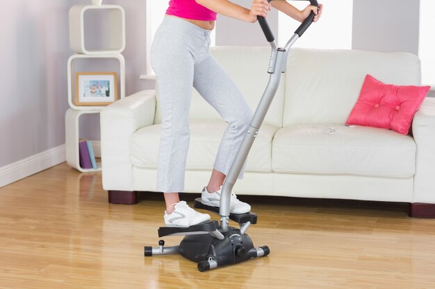 Foto entrenamiento deportivo de la mujer en la máquina del paso