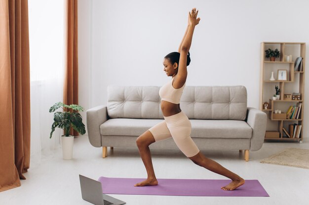 Entrenamiento doméstico. Joven Mujer Negra Deportiva Haciendo Ejercicio De Tablón En Casa, Entrenando En La Sala De Estar