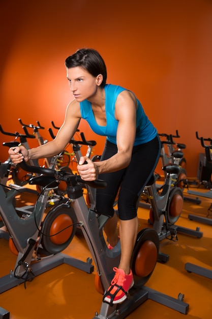 Entrenamiento de ejercicios aeróbicos spinning mujer en el gimnasio