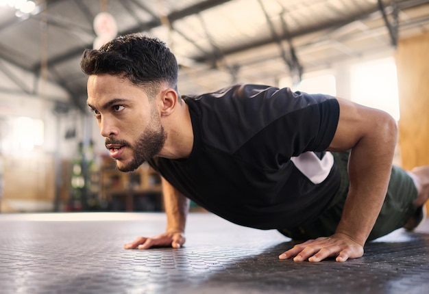 Entrenamiento físico y empuje con el hombre en el gimnasio para entrenar los músculos y la resistencia al entrenamiento Determinación fuerte y poderosa con el culturista y el ejercicio de piso para el bienestar deportivo y el atleta