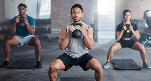 Entrenamiento físico y pesas rusas con un entrenador personal en clase con un grupo de estudiantes para hacer ejercicio Gimnasio de retratos y fuerte con un entrenador entrenando con pesas a un atleta hombre y una mujer en un club deportivo