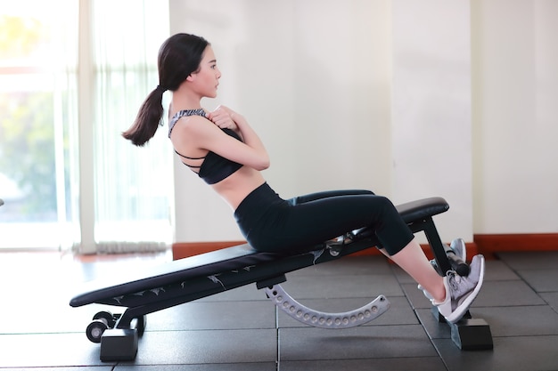 entrenamiento joven de la mujer sana y deportiva en el gimnasio