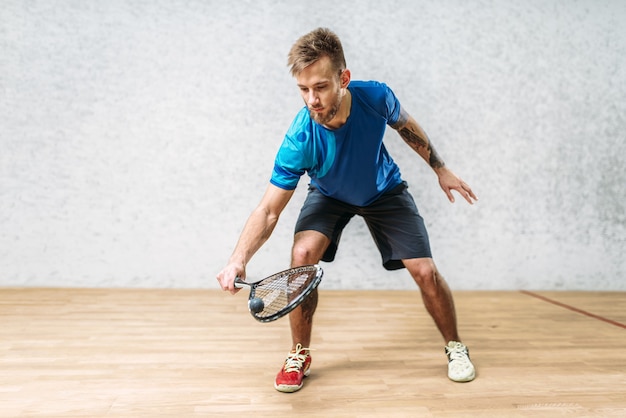 Entrenamiento de juego de squash, jugador masculino con raqueta