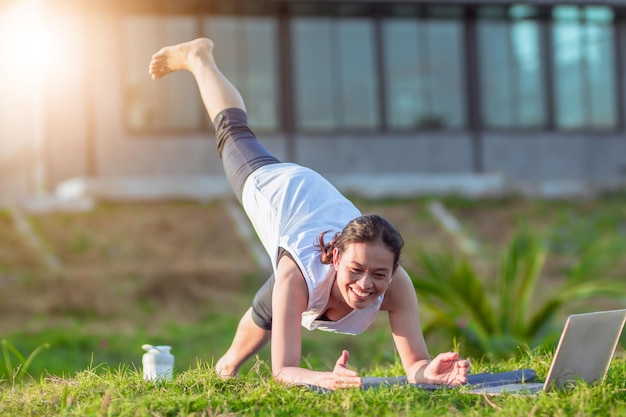 Entrenamiento en línea de video de internet de entrenador de mujer asiática delgada deportiva joven hatha yoga