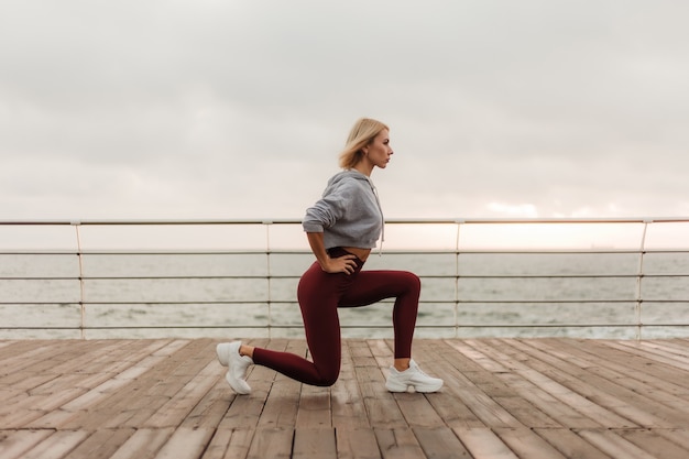 Entrenamiento matutino Concepto de estilo de vida saludable Mujer atractiva joven en ropa deportiva se calienta