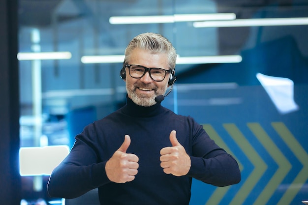 Foto entrenamiento motivacional en línea de un joven y apuesto psicólogo de cabello gris en auriculares con un