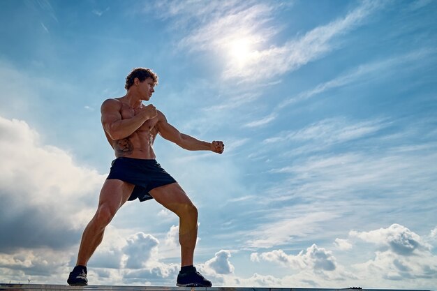 Un entrenamiento de muay thai o kickboxer con boxeo de sombra al aire libre