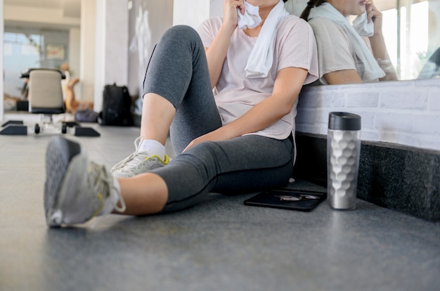 Entrenamiento de mujer asiática y trabajando solo en línea en GYM. Distanciamiento social y nuevo estilo de vida normal.