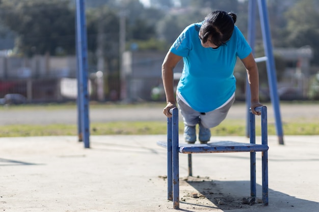 Entrenamiento de mujer de edad mexicana en un patio de recreo