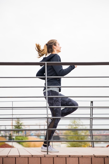 Entrenamiento de mujer joven por valla