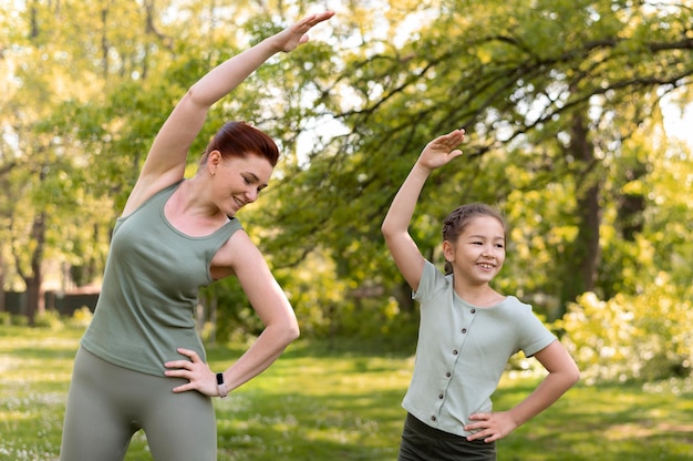 Foto entrenamiento de mujer y niña sonriente