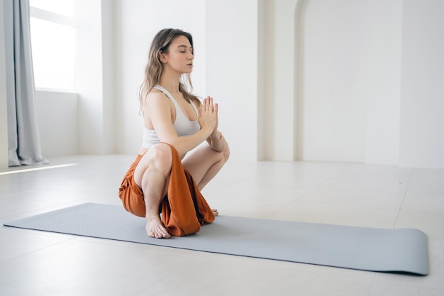 Entrenamiento de mujer de pose de yoga en un elegante gimnasio