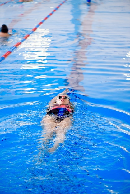 Entrenamiento de natación en la piscina deportiva. El entrenador muestra una clase magistral de natación.