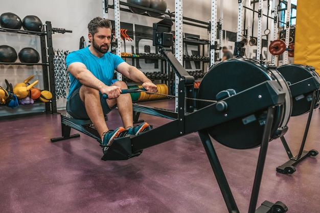 Entrenamiento de trabajo. Deportista en un gimnasio tirando de pesas y trabajando en el núcleo