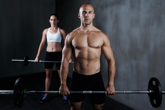 Entrenando para estar en forma para pelear. Captura recortada de un hombre y una mujer haciendo ejercicio con pesas.