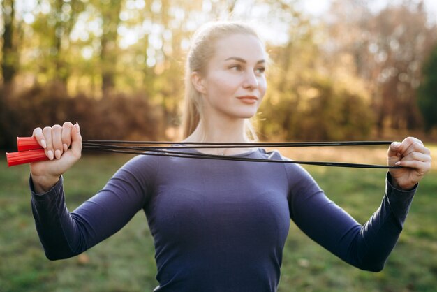 Entrenando en el parque, chica sosteniendo una comba.