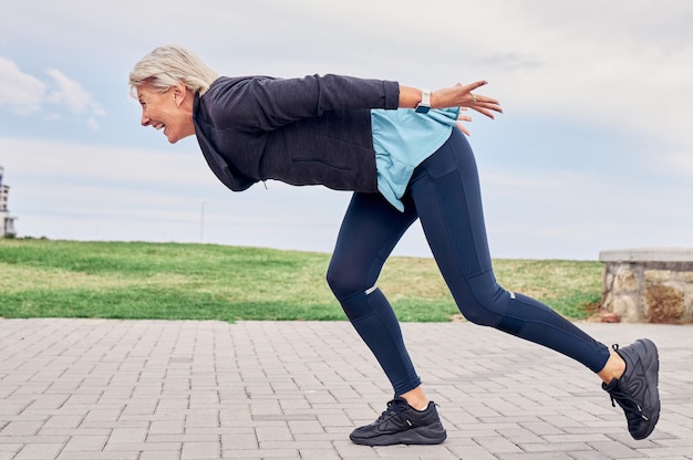 Entrene a una mujer mayor y corra en el parque para obtener bienestar energético o maratón de cardio Feliz anciana ejercicio y corredor al aire libre para entrenamiento deportivo, fitness saludable y sonrisa para el movimiento de acción